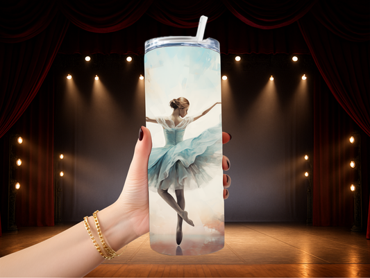 Hand holding 3D ballerina tumbler with stage lights in background